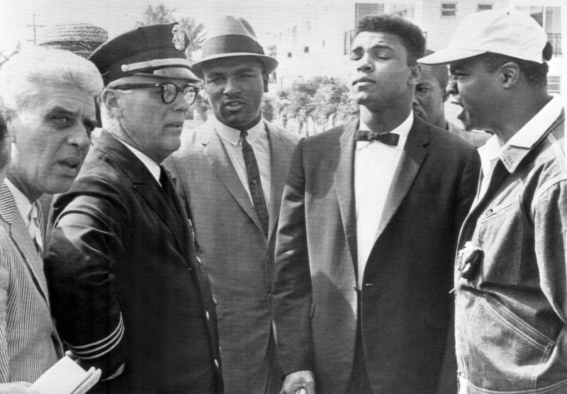 Cassius Clay's attempt to picket Sonny Liston's training camp at Surfside was stopped cold by a dtermined police chief, Wiley Barefoot, 2/7. Clay and his brother, Rudy (left center) and assistant trainer Drew Brown (r) led the parade.Getty Images